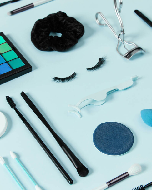 Mise en page créative avec accessoires de maquillage sur fond bleu pastel - Photo, image