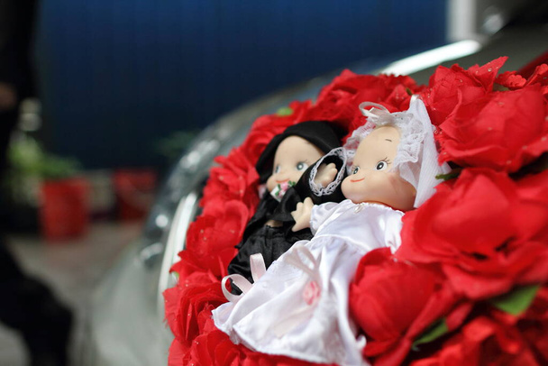Knot γαμήλιο αυτοκίνητο διακοσμημένο με χαριτωμένες κούκλες και τριαντάφυλλα - Φωτογραφία, εικόνα