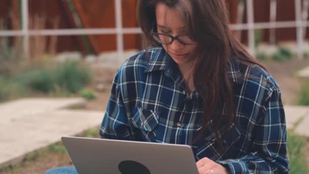 Primer plano de las imágenes de la mujer joven utilizando el ordenador portátil al aire libre - Metraje, vídeo