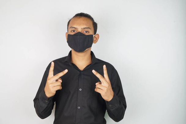 Maske takan genç bir adam, yüz maskesi, korona savaşçıları, dezenfektan görüntüsü kullanıyor. Vastav Kharat . - Fotoğraf, Görsel