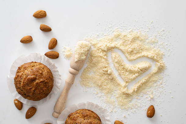 gluten free baked goods, muffins on almond flour with nuts on a white background, love heart symbol, keto food, top view - 写真・画像