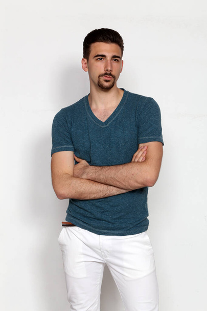 Atraktivní mužský model s krátkými vlasy pózující ve studiu na izolovaném pozadí. Styl, trendy, módní koncept. - Fotografie, Obrázek