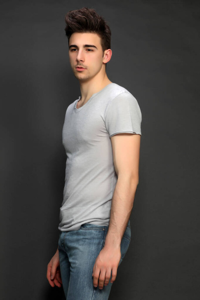 Attractive male model with short hair posing in studio on isolated background. Style, trends, fashion concept. - 写真・画像