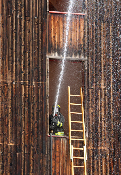 Firefighter with hydrant in action when switching off a fire dur - Photo, Image