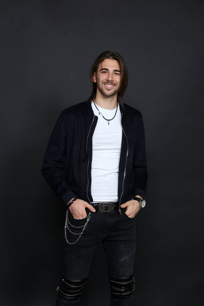 Attractive male model with long hair and beard posing in studio on isolated background. Style, trends, fashion concept. - Foto, afbeelding
