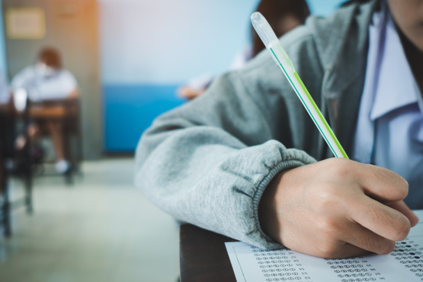 Uczniowie piszący i czytający arkusze odpowiedzi ćwiczenia w klasie szkoły ze stresem - Zdjęcie, obraz