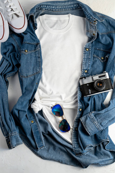 White T-shirt with place for text. Blue denim shirt, sneakers, glasses - a set of clothes for walking. T-shirt mockup for printing. Stylish kit. Copy space. - Φωτογραφία, εικόνα