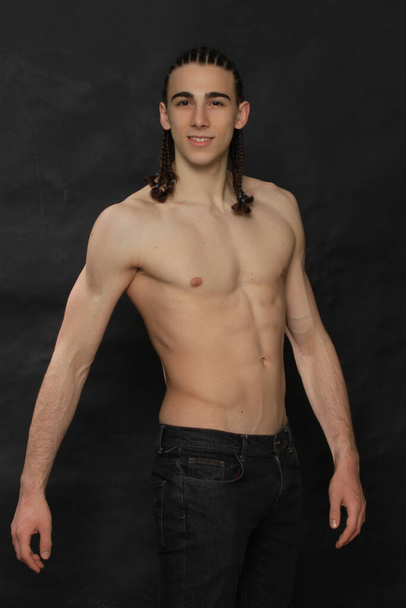 Attractive male model with long hair posing in studio on isolated background. Style, trends, fashion concept. - Foto, Bild
