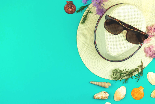 Top view καλοκαιρινές διακοπές με τροπικά φύλλα και γυναικεία αξεσουάρ παραλίας σε φωτεινό φόντο, ψάθινο καπέλο, γυαλιά ηλίου και θαλασσοταραχή - Φωτογραφία, εικόνα