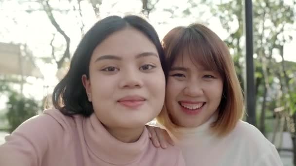 Junge glückliche asiatische hübsche Mädchen Paar Freund Blogger Selfie Blick in die Kamera mit Lächeln Gesicht in der Stadt Straße. Nahaufnahme Porträt lustige lebenslustige junge Frauen, Urlaubskonzept Outdoor. - Filmmaterial, Video