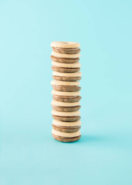 Sandwich biscuit stuffed with chocolate filling arranged one on top of the other vertically. Blue background - Φωτογραφία, εικόνα