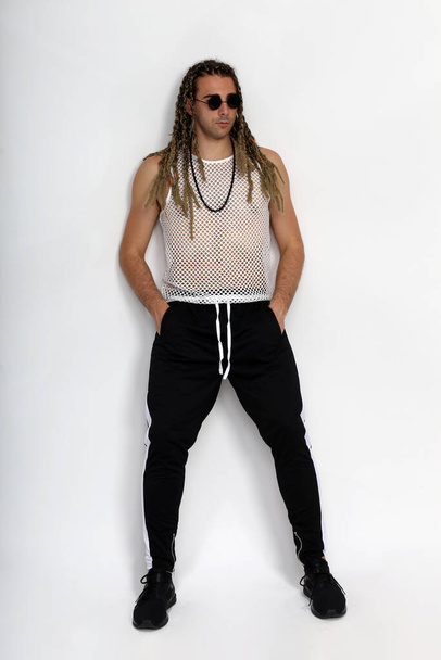 Attractive blonde male model with combination of braids and dreadlocks posing in studio on isolated background. Style, trends, fashion concept. - Foto, Imagem
