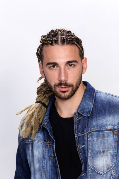 Attractive blonde male model with combination of braids and dreadlocks posing in studio on isolated background. Style, trends, fashion concept. - Foto, immagini