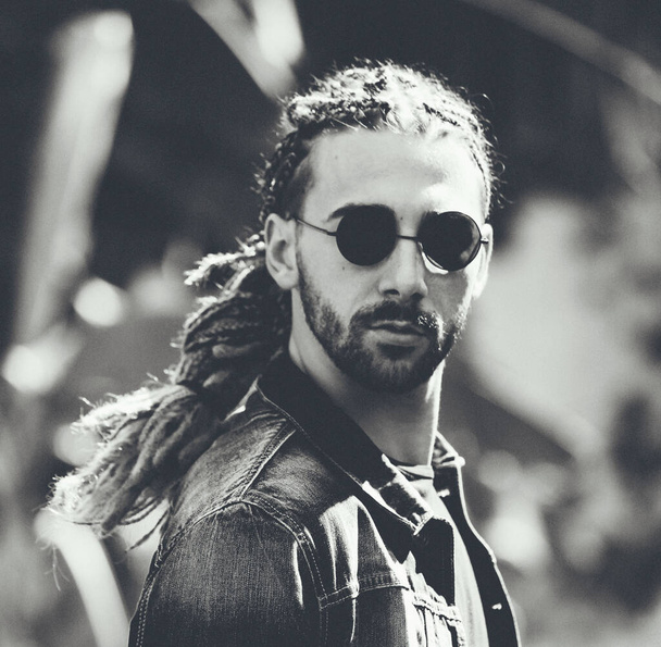 Attractive, young blonde bearded male model with combination of braids and dreadlocks posing in the wild. Style, trends, fashion concept. - Foto, immagini