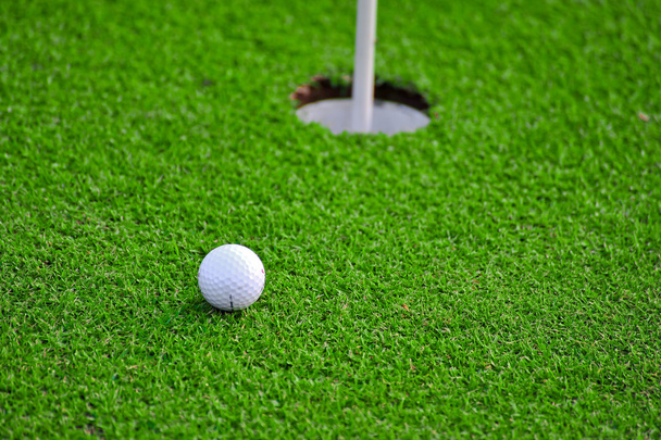 golfový míček a golfové hole na zelené trávě  - Fotografie, Obrázek