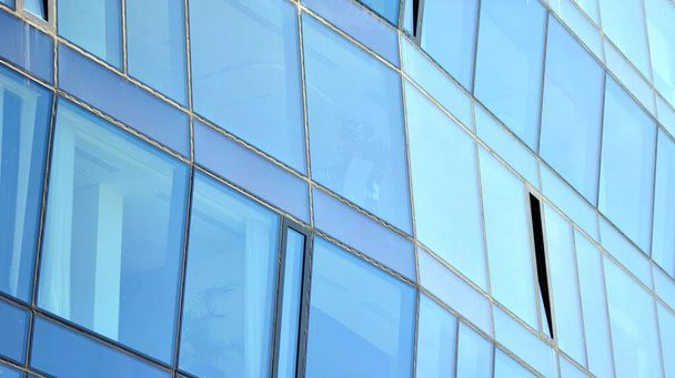 Janelas espelhadas da fachada de um edifício de escritórios. Textura abstrata do edifício de escritórios moderno de vidro azul. Contexto empresarial. - Foto, Imagem