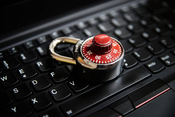 Siyah bir klavyede şifreli bir kilidin kapatılması. - Fotoğraf, Görsel