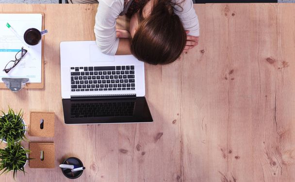Young woman sleeping on laptop in the workplace - Фото, зображення