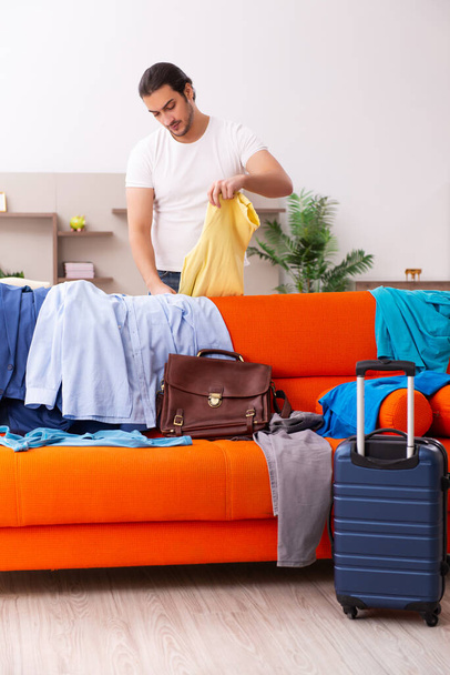 Young man student preparing for trip at home - Photo, Image