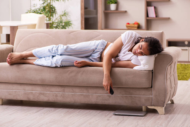 Jeune homme paresseux dans un concept de sommeil excessif à la maison - Photo, image