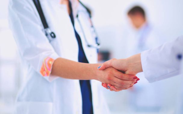 Young medical people handshaking at office - 写真・画像