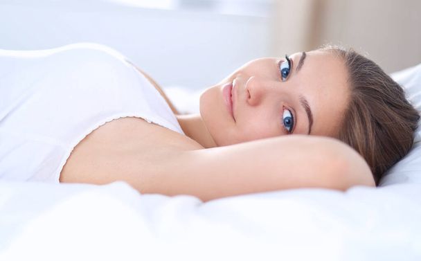 A beautiful young woman lying in bed comfortably and blissfully - Foto, immagini