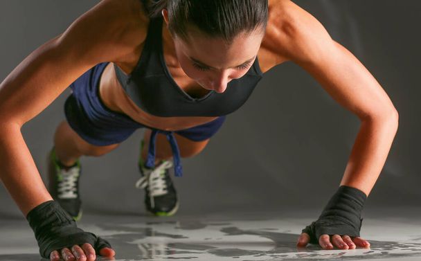 Young woman doing push ups on a mat. - Zdjęcie, obraz