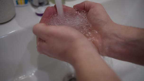 Homem segura suas palmas sob uma corrente de água da torneira, close-up - Filmagem, Vídeo