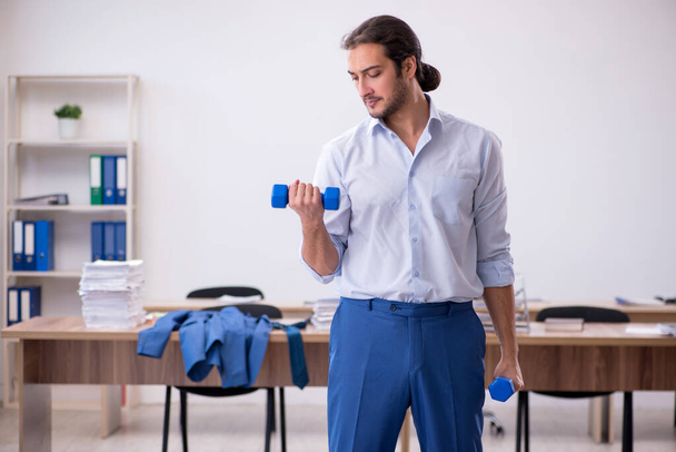 Young male employee doing sport exercises during break - Photo, Image