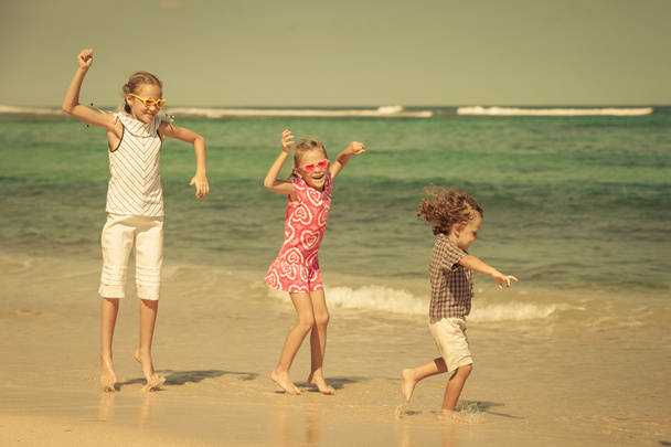 Crianças felizes brincando na praia na hora do dia
 - Foto, Imagem