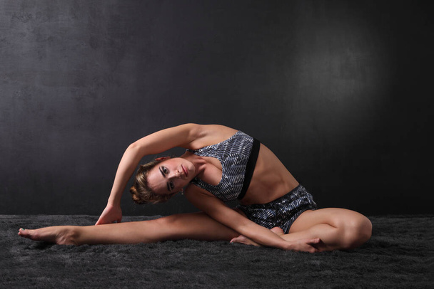 fiatal sportoló nő vékony test sötét háttér - Fotó, kép