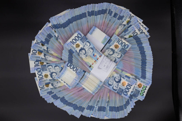 Een stapel van duizend Filippijnse bankbiljetten. Contant geld van Duizend dollar biljetten, Peso achtergrond afbeelding. - Foto, afbeelding