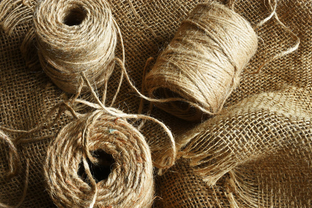 A close up image of coils of beige burlap string on burlap fabric.  - Φωτογραφία, εικόνα