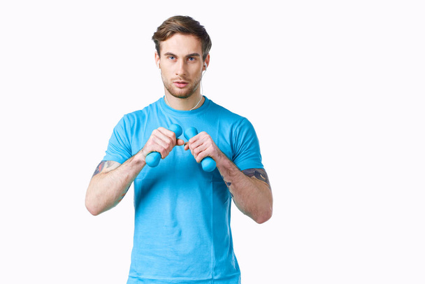 deportivo hombre en azul camiseta de mancuernas en manos fitness recortado ver - Foto, Imagen