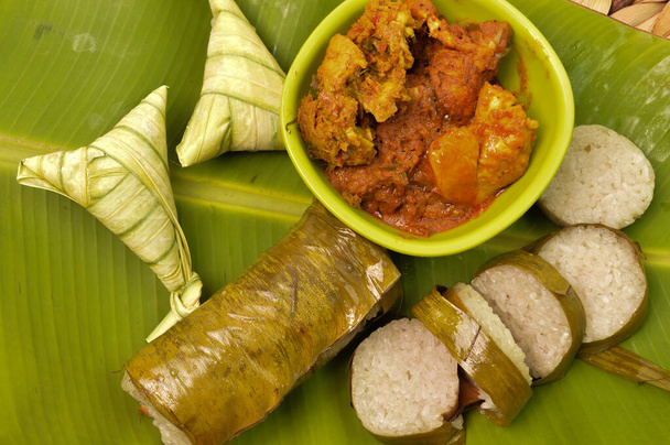 La comida tradicional malaya llama como Lemang y Ketupat arroz o Ketupat Palas con pollo rendang. Arroz glutinoso se envuelve con hoja de plátano, se come con rendang pollo y serunding. - Foto, imagen