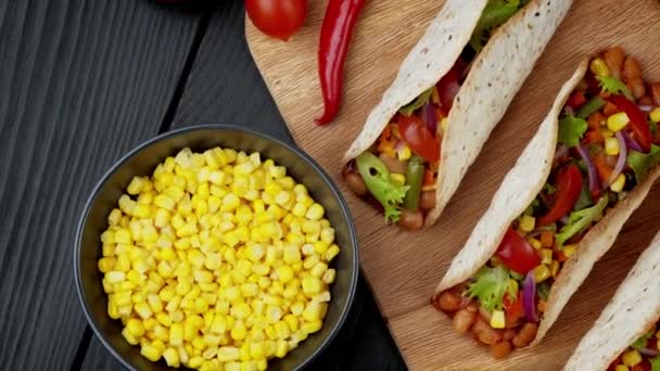Comida tradicional mexicana. Sabrosos tacos con verduras. Ingredientes coloridos sobre fondo negro - Metraje, vídeo