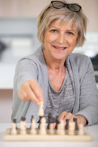portrait of senior woman playing chess at leisure - Foto, afbeelding