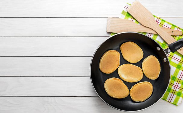 Pan with pancakes on the white woobed table. Top view. Cooking food. - Foto, immagini