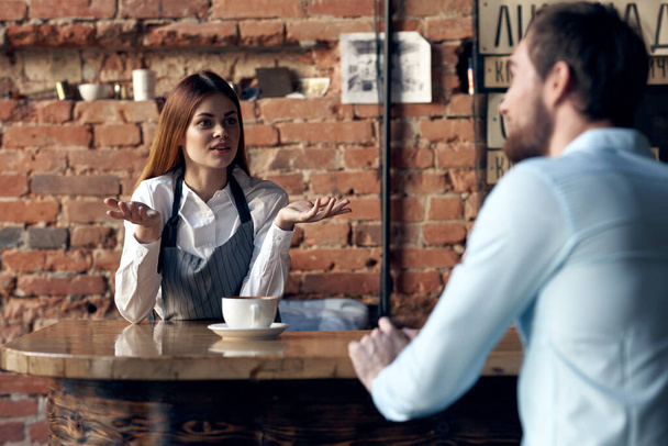 woman waiter brings coffee to a cafe client - Photo, Image