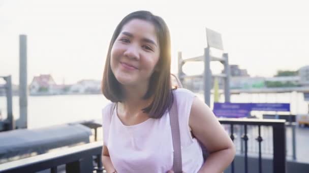 Happy young Asian woman blogger tourist with casual style looking at camera take selfie video call enjoy with beautiful sunset river view cafe in city town, Lifestyle tourist travel holiday concept. - Footage, Video