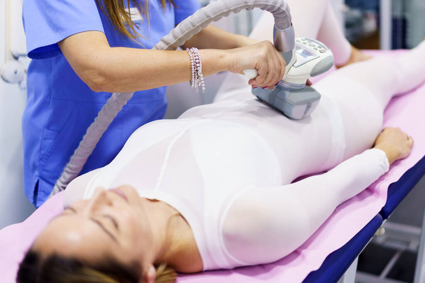Frau im Spezialanzug bei einer Anti-Cellulite-Bauchmassage mit Wellnessapparat - Foto, Bild