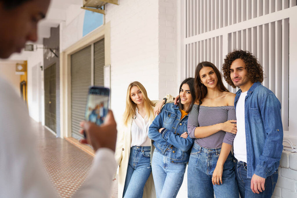 Мульти-этническая группа друзей фотографирует со смартфона на улице. - Фото, изображение