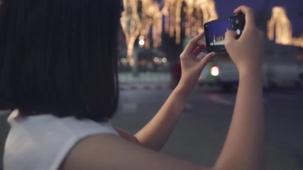 Szczęśliwy młody azjatycki turysta dziewczyna z casual styl trzymać telefon komórkowy relaks wesoły zrobić zdjęcie pokojowe zdjęcie świątyni w Bangkok miasta w nocy. Styl życia turystyka wakacje koncepcja. - Materiał filmowy, wideo