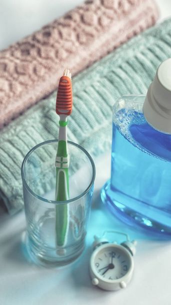 Ağız gargarası diş fırçası ve havluların banyo sabah hijyen rutin diş sağlığı eğitimi konseptine yakın plan. - Fotoğraf, Görsel