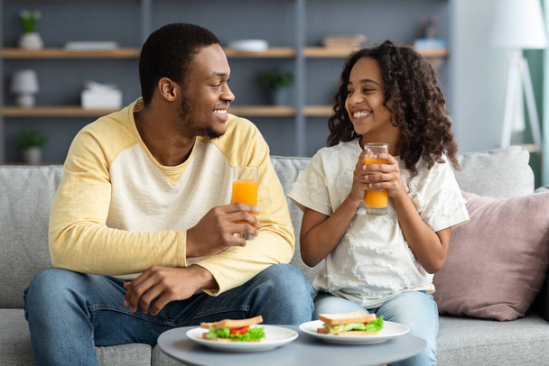 Beautiful black family father and daughter having snack at home - Foto, imagen