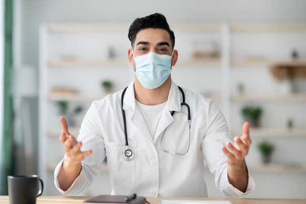 Médico en máscara facial trabajando en el hospital, dando recomendaciones - Foto, Imagen