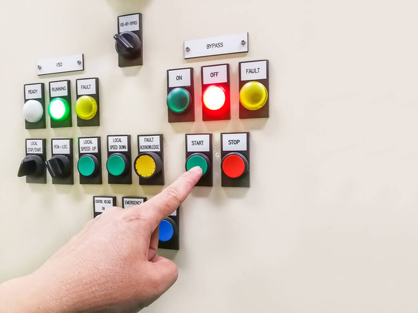 Endüstriyel santralin kontrol panelini tutarak ve düğmeye basarak veya çevirerek elektrik seçici anahtarı, düğme motor kontrol kabini - Fotoğraf, Görsel