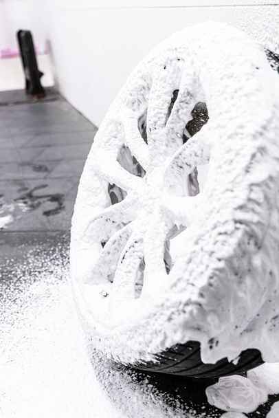 Reiniging van auto wiel en band met actief schuim - Foto, afbeelding