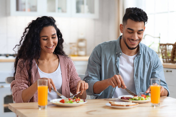 Пара Щоденне життя. Щасливі близькосхідні подружжя їдять сніданок на кухні
 - Фото, зображення