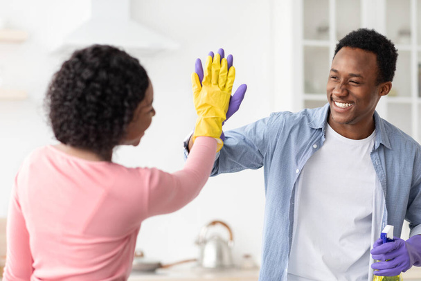 Эмоциональные черные домовладельцы празднуют хорошую работу, кухонный интерьер - Фото, изображение